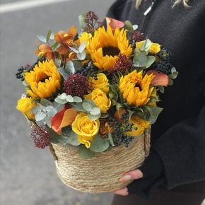Композиция в сумке "Тональность" из подсолнухов, калл, ягод вибирнума, лимонных роз, скиммии и орхидеи в Коломне