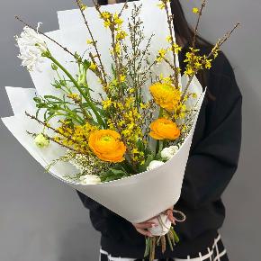 Весенний букет с желтыми ранункулюсами и цветущими ветками форзиции в Коломне